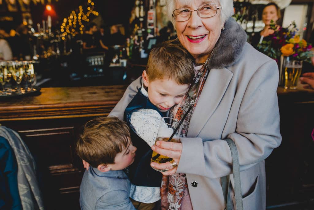 an old lady holding two young boys at a wedding reception