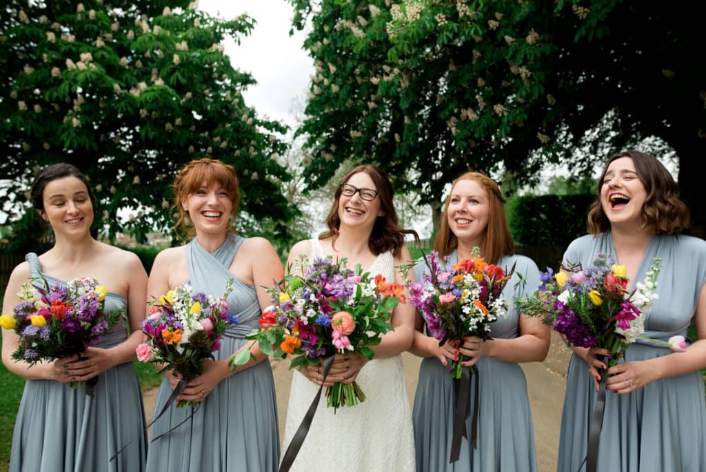a bride lined up with her bridesmaids holding flowers