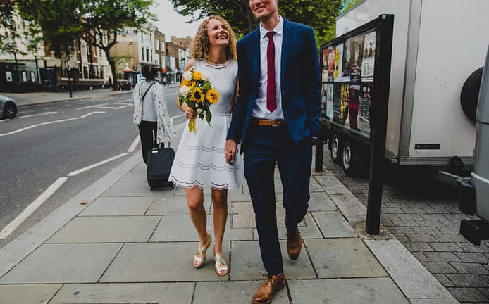 a bride and groom walking down Islington High Street