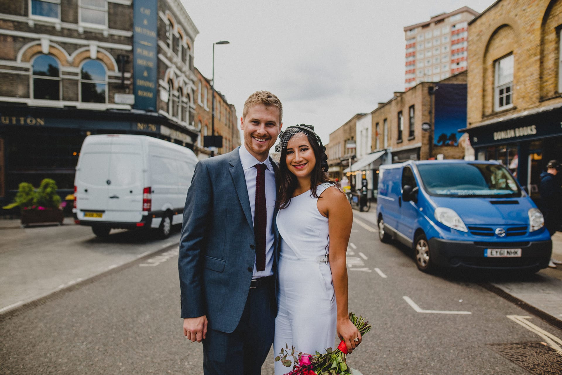 a portrait of a bride and groom in an East London street